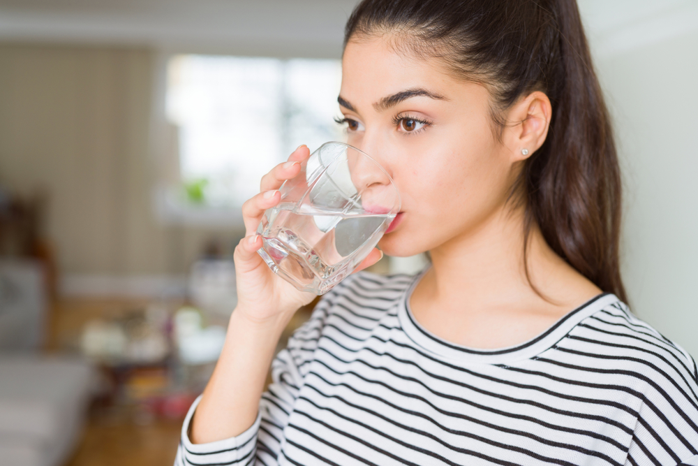 Woman drinking water after IV Therapy in Scarsdale, NY